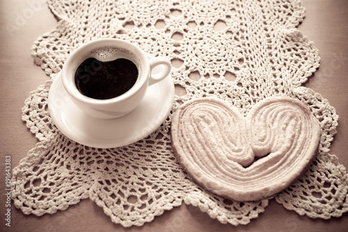 white cup of black coffee and a sweet buttery cookie on the table photo