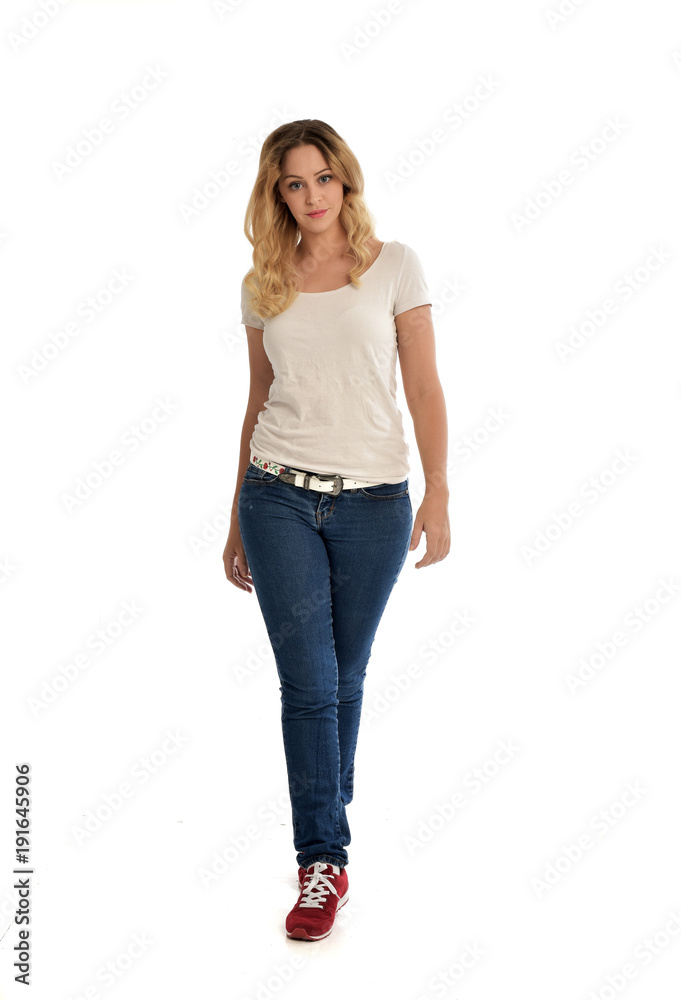 full length portrait of blonde girl wearing white shirt and jeans. standing pose, isolated on white studio background. full length portrait of blonde girl wearing white shirt and jeans. standing pose, isolated on white studio background.
