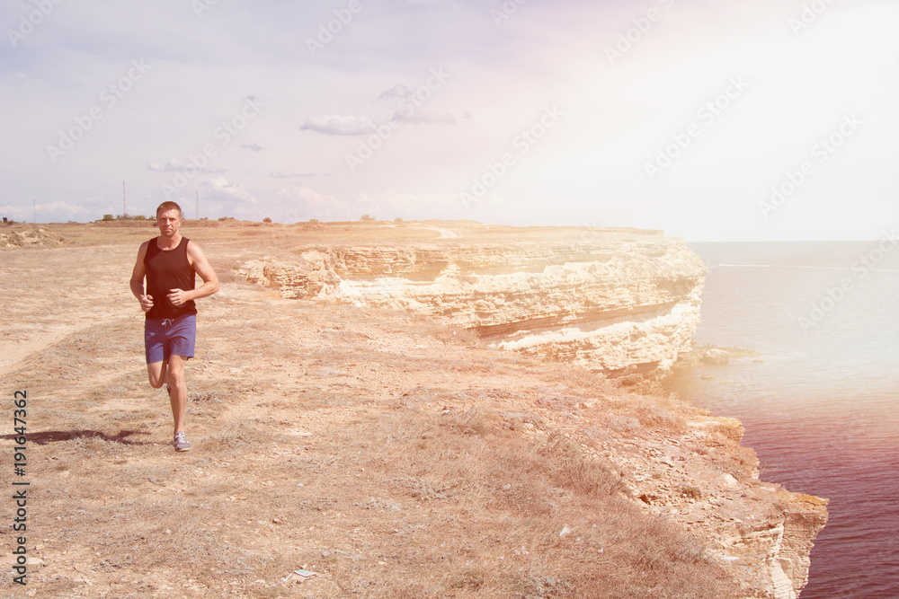 Running and a healthy lifestyle. A man runs along the beach. 