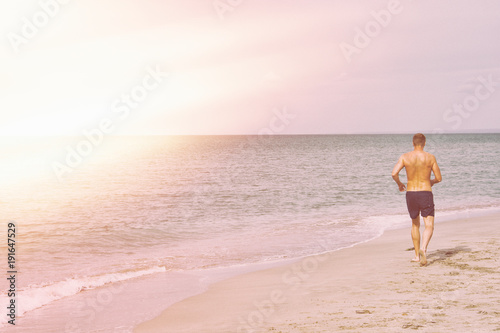Sport and a healthy lifestyle. A man runs along the beach.