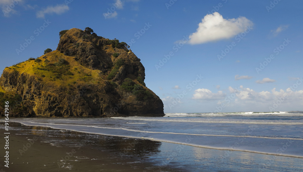 Black Sand Sunny Beach. Mountain Bathed in Sunlight, Covered by Grass and Trees.Blue Sky With Fluffy Cloud. Steep Green Mountain Rising From the Water.Landscape Without People. Sky Reflect in Wet Sand Black Sand Sunny Beach. Mountain Bathed in Sunlight, Covered by Grass and Trees.Blue Sky With Fluffy Cloud. Steep Green Mountain Rising From the Water.Landscape Without People. Sky Reflect in Wet Sand
