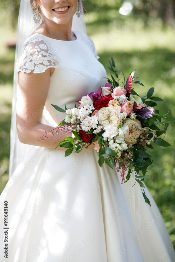 Bride holds rich wedding bouquet in her arms Bride holds rich wedding bouquet in her arms