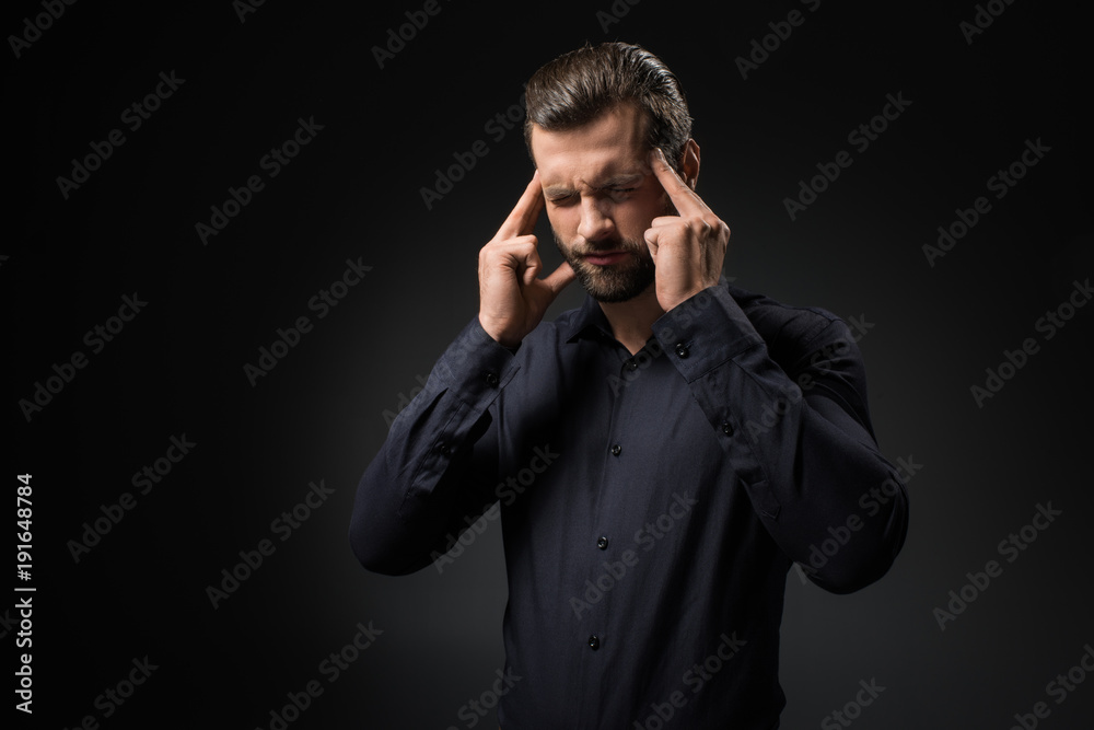 portrait of young man having headache isolated on black portrait of young man having headache isolated on black