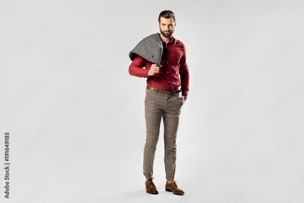 stylish man with jacket in hand posing isolated on grey stylish man with jacket in hand posing isolated on grey