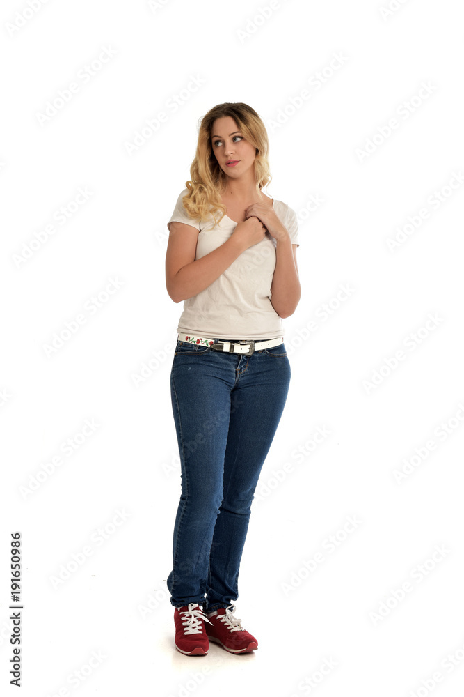 full length portrait of blonde girl wearing white shirt and jeans. standing pose, isolated on white studio background. full length portrait of blonde girl wearing white shirt and jeans. standing pose, isolated on white studio background.