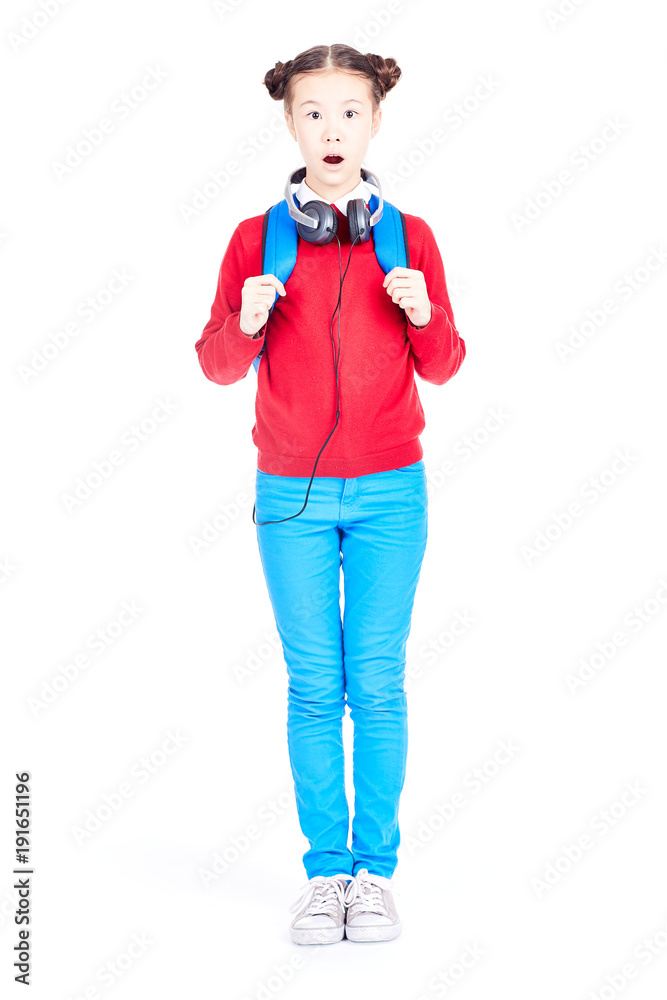 Portrait of Asian school girl posing on white background with backpack and headphones around her neck Portrait of Asian school girl posing on white background with backpack and headphones around her neck