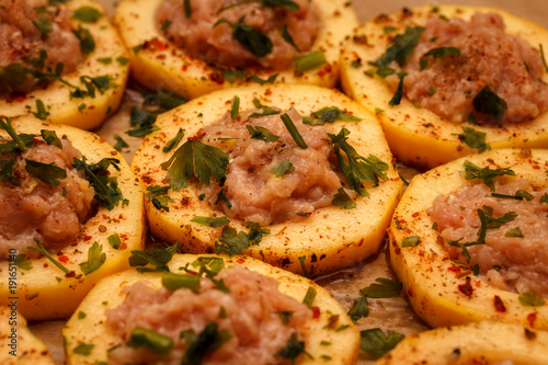 Sliced fresh slices of zucchini, filled with minced meat, on food paper. Food Background