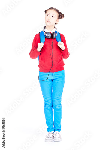 Portrait of Asian school girl posing on white background with backpack and headphones around her neck