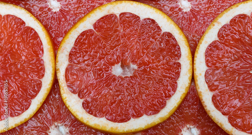 Juicy grapefruit slices lie in the form of a pattern photo