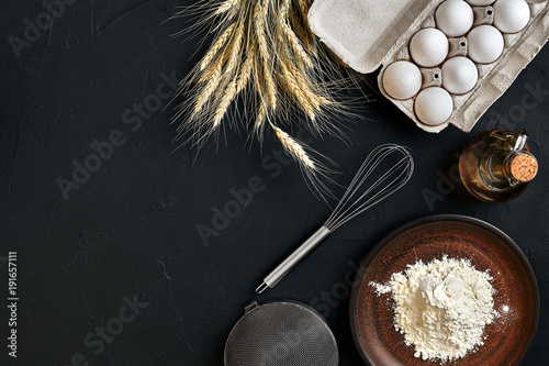 Preparation cooking baking kitchen table brown dishes ware fresh grocery different ingredients: eggs, flour, oil, stuff top view photo