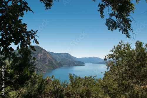 Photo from the height with lake and mountains in the background and trees