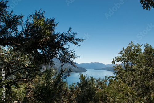 Photo from the height with lake and mountains in the background and trees