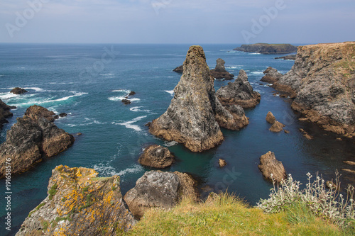 The image of the famous places on the island Belle Ile en Mer - Aiguilles de Port-Coton with the waves pounding on the rocks, each of which has its name from its shape.