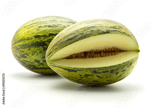 Two melons Piel de Sapo (Santa Claus Christmas variety) one cut open isolated on white background green striped outer rind.
