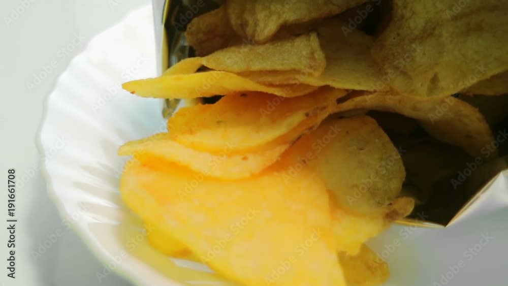 Homemade potato chips. Fast food. Popular junk food. Potato tubers and chips rotate smoothly on bamboo napkin. Diabetic diet. Homemade potato chips. Fast food. Popular junk food. Potato tubers and chips rotate smoothly on bamboo napkin. Diabetic diet.