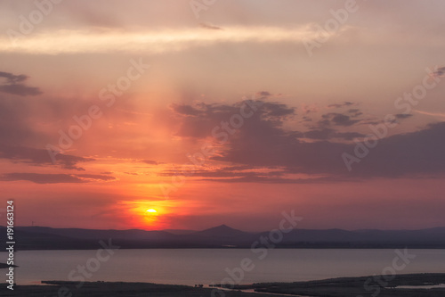 Cloudy colorful sunset over the hills and lake, Enisala, Dobrogea, Romania