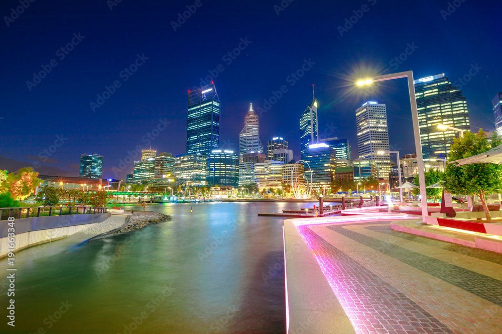 Walkway with night lighting at Elizabeth Quay marina and Esplanade with skyscrapers on Swan River. Perth Downtown skyline the capital city of Western Australia.