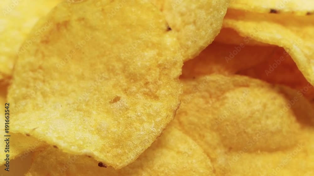 Homemade potato chips. Fast food. Popular junk food. Potato tubers and chips rotate smoothly on bamboo napkin. Diabetic diet. Homemade potato chips. Fast food. Popular junk food. Potato tubers and chips rotate smoothly on bamboo napkin. Diabetic diet.