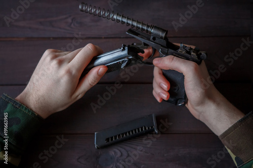 Photography Men's hands dismantle and clean the gun, training in the army