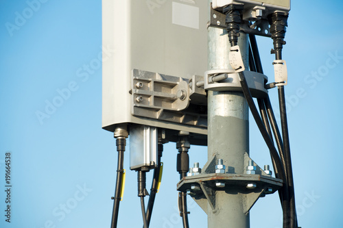 Telecommunication tower with sector antennas against the blue sky photo