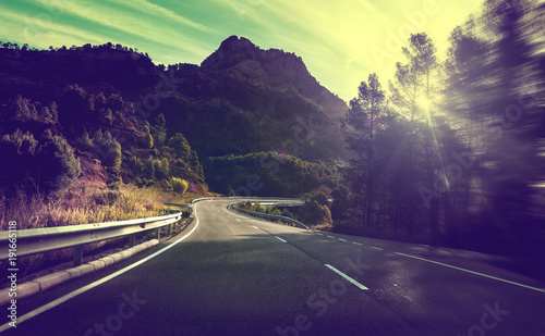 Concepto de viajes por carretera.Carretera de montaña con curvas y puesta de sol.Seguridad y precaución conduciendo.