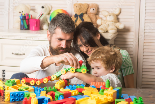 Parenthood concept. Family playing with plastic blocks.