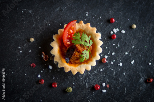 top view of tomato tartelette with tomato and olive slice