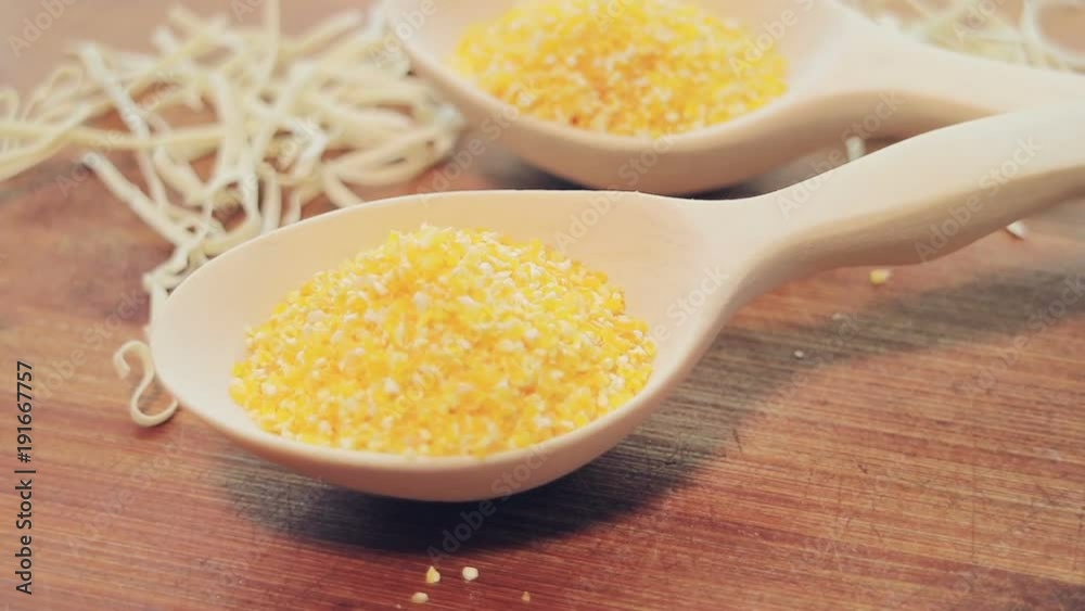 Corn groats in a wooden spoon. Healthy diet food. Vegetarianism. Smooth rotation. Bamboo board. Corn groats in a wooden spoon. Healthy diet food. Vegetarianism. Smooth rotation. Bamboo board.