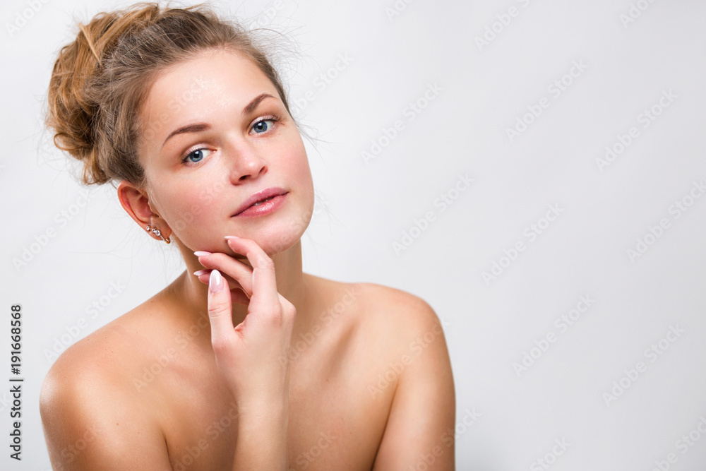Fototapeta premium Portrait of a beautiful young woman on a gray background