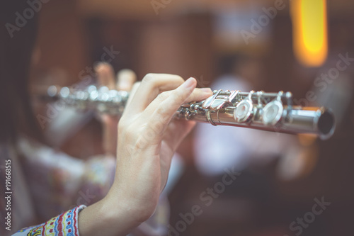 A woman is playing  flute.