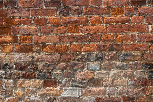 An old weathered  damaged  badly repaired red brick wall full frame