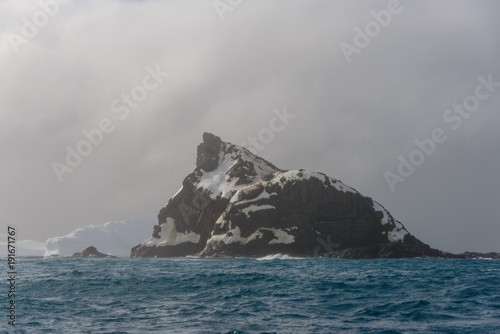 Rock with snow in sea © Alexey Seafarer
