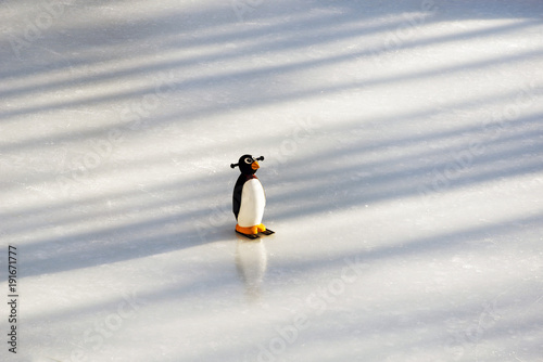 A figure skating ring and a plastic penguin on top of the ice piste