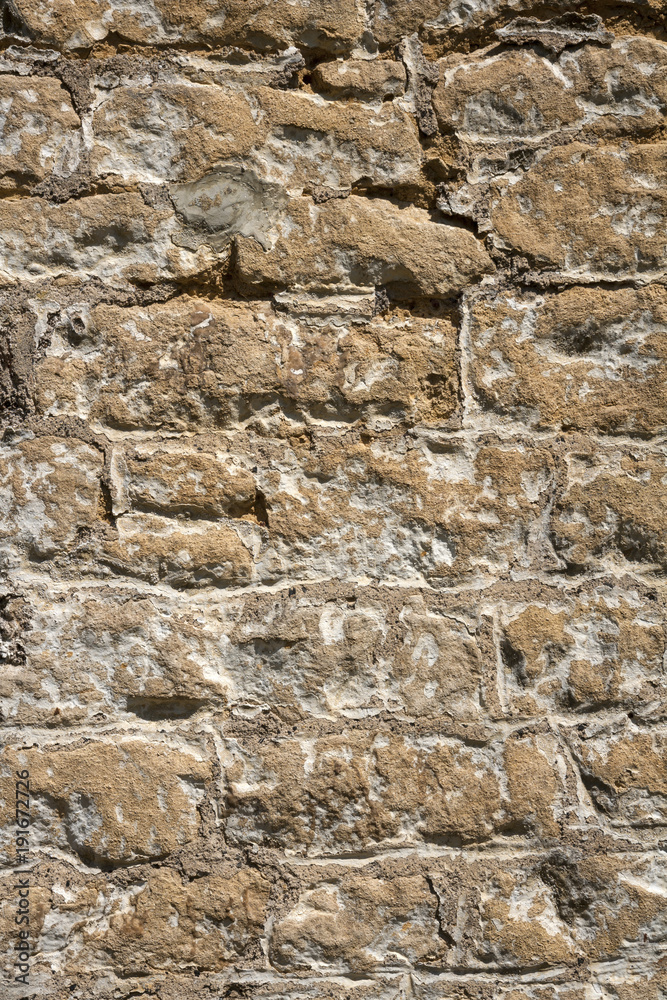 An old previously painted weathered stone wall needs repairs. Construction full frame texture background.