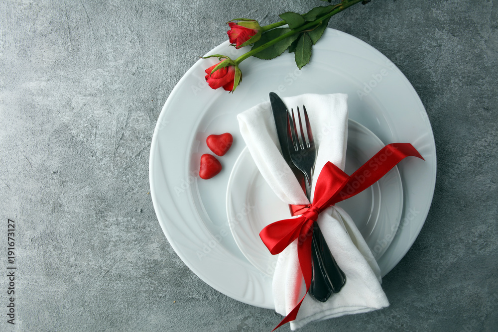 Festive table setting for Valentine's Day with fork, knife and rose Festive table setting for Valentine's Day with fork, knife and rose