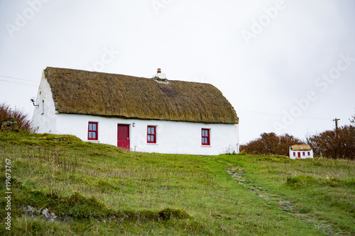thatch roof cottage on inishmore with matching doghouse