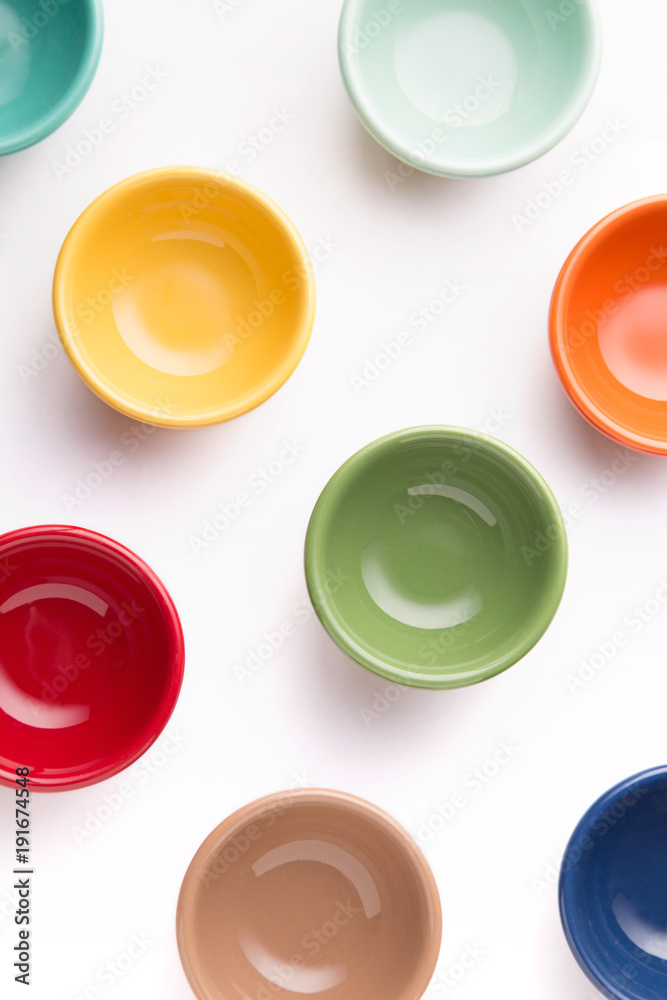 Pattern of small colorful bowls on a white background viewed from above. Top view. Pattern of small colorful bowls on a white background viewed from above. Top view.