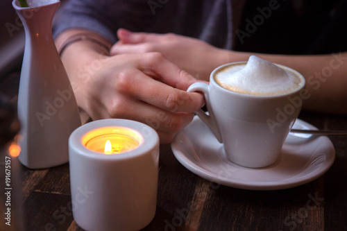 closeup of woman sitting at cafe with cup of coffee