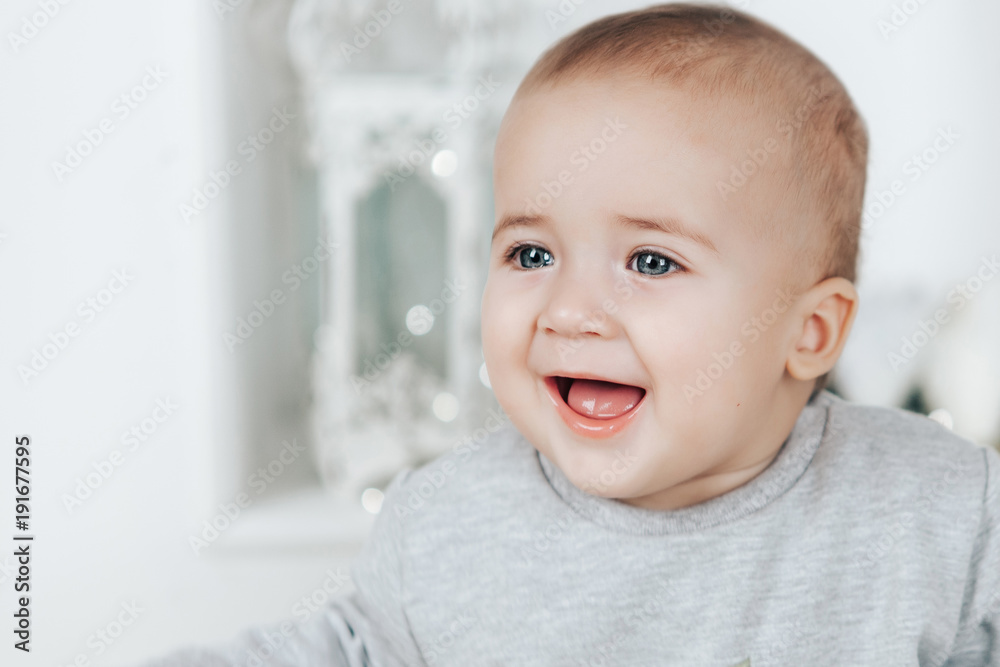 Baby boy rejoices looking away on a light background