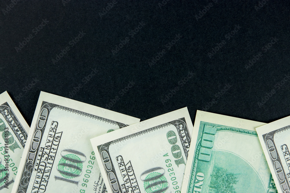 One hundred dollar bills on black background with copyspace One hundred dollar bills on black background with copyspace
