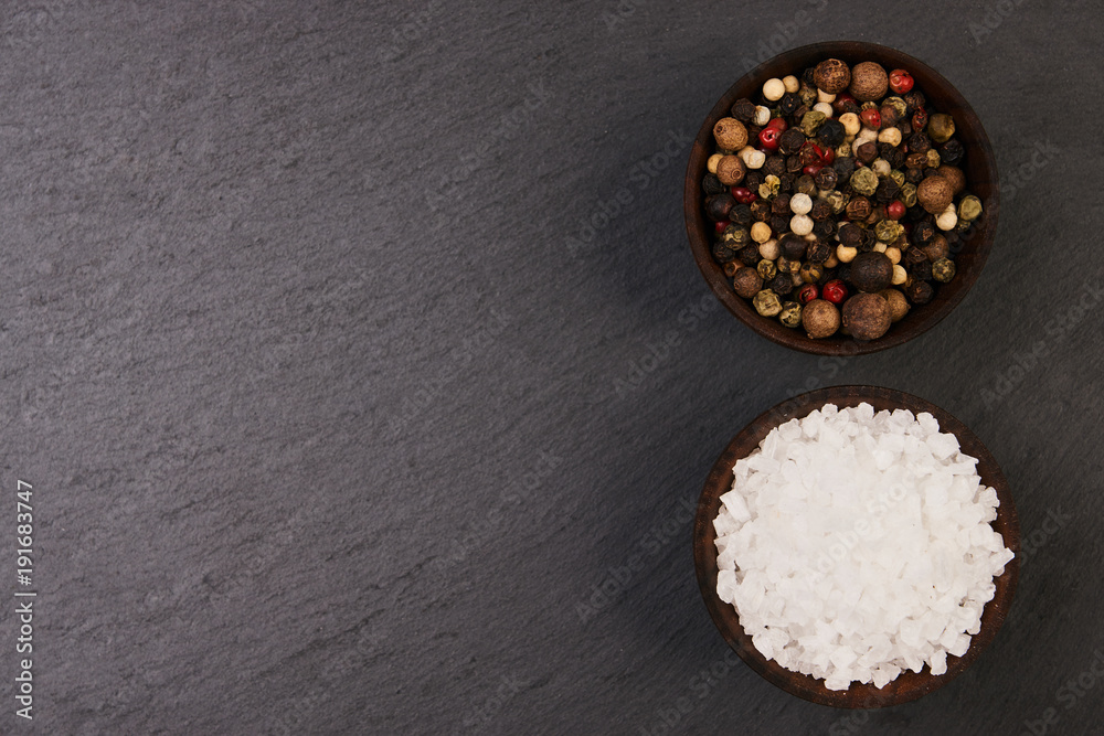 Peppercorns and sea salt in a wooden bowl Peppercorns and sea salt in a wooden bowl