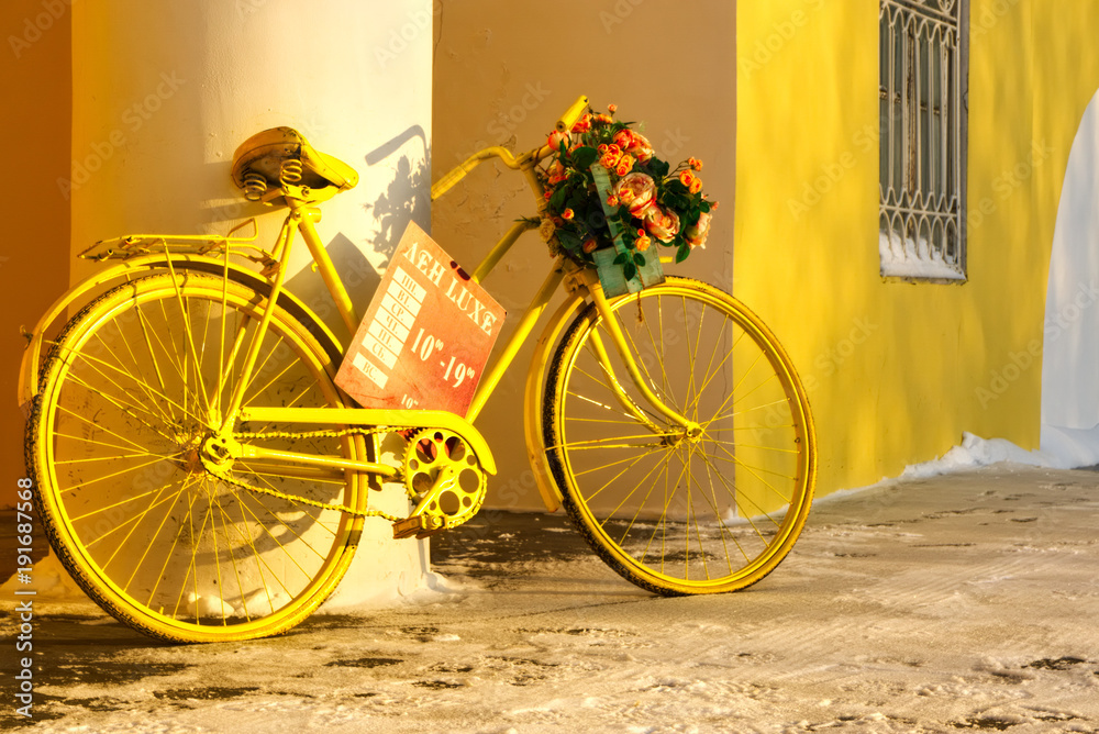 Yellow bicycle with flowers.