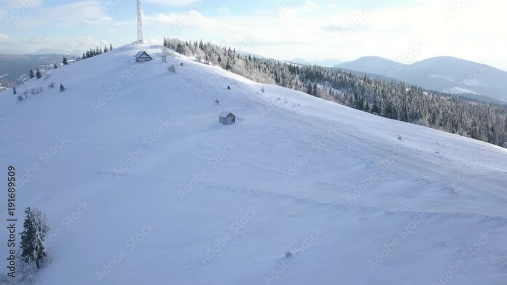 View from the height on people driving snowmobile on beautiful snowy mountain slope. Clear frosty weather View from the height on people driving snowmobile on beautiful snowy mountain slope. Clear frosty weather