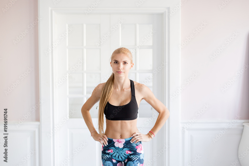 home fitness. Young woman warming up before training doing exercises to stretch her muscles and joints