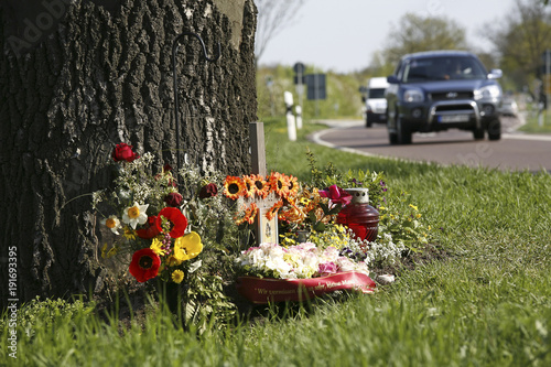 Straßenkreuz mit Blumen