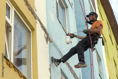 steeplejack at work on the wall of the building