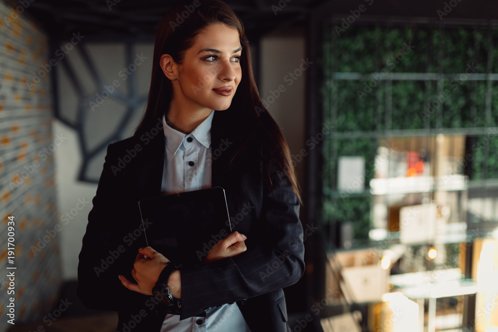 Happy businesswoman holding tablet and looking at side. Happy businesswoman holding tablet and looking at side.