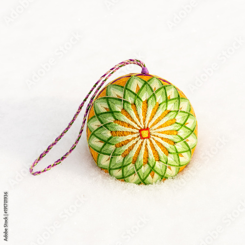 Foto Bright decorative ball of the temari lie on the snow in the winter