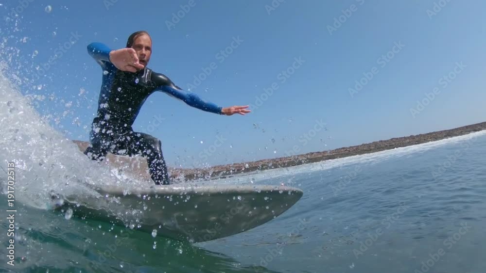 SLOW MOTION, CLOSE UP, UNDERWATER: Awesome male surfer rides a large approaching barrel wave. Pro surfboarder carving waves in Lobos. Cinematic shot of fit male riding wave in the Canary Islands. SLOW MOTION, CLOSE UP, UNDERWATER: Awesome male surfer rides a large approaching barrel wave. Pro surfboarder carving waves in Lobos. Cinematic shot of fit male riding wave in the Canary Islands.