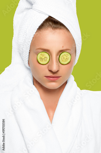 Skin care, woman with cucumbers on eyes and towel on her head